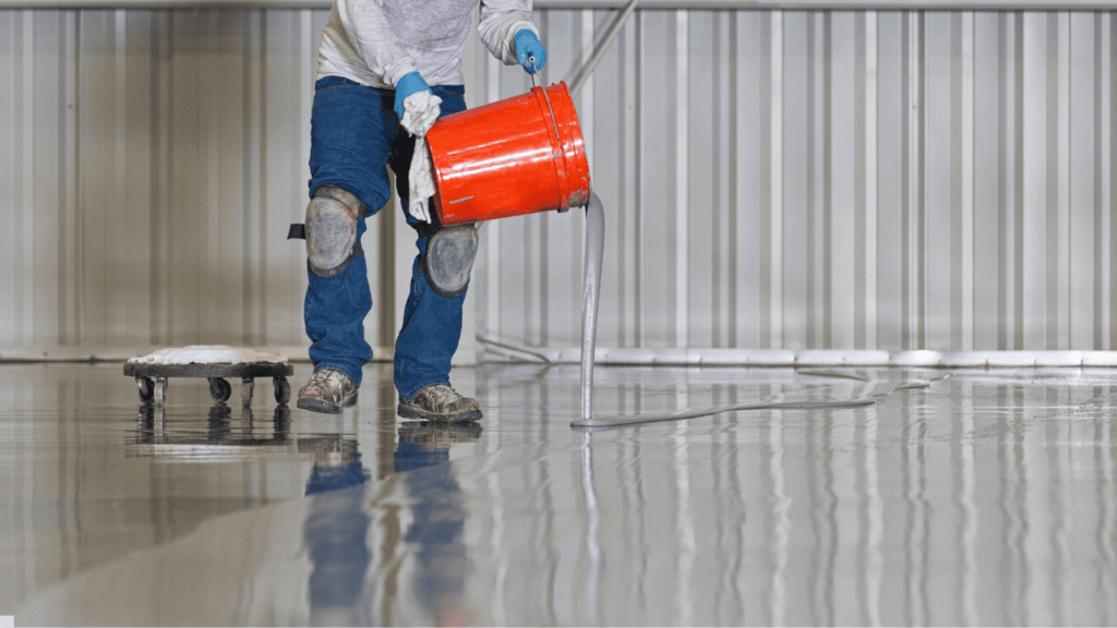 Technician applying floor coating in a warehouse facility Technician applying floor coating in a warehouse facility